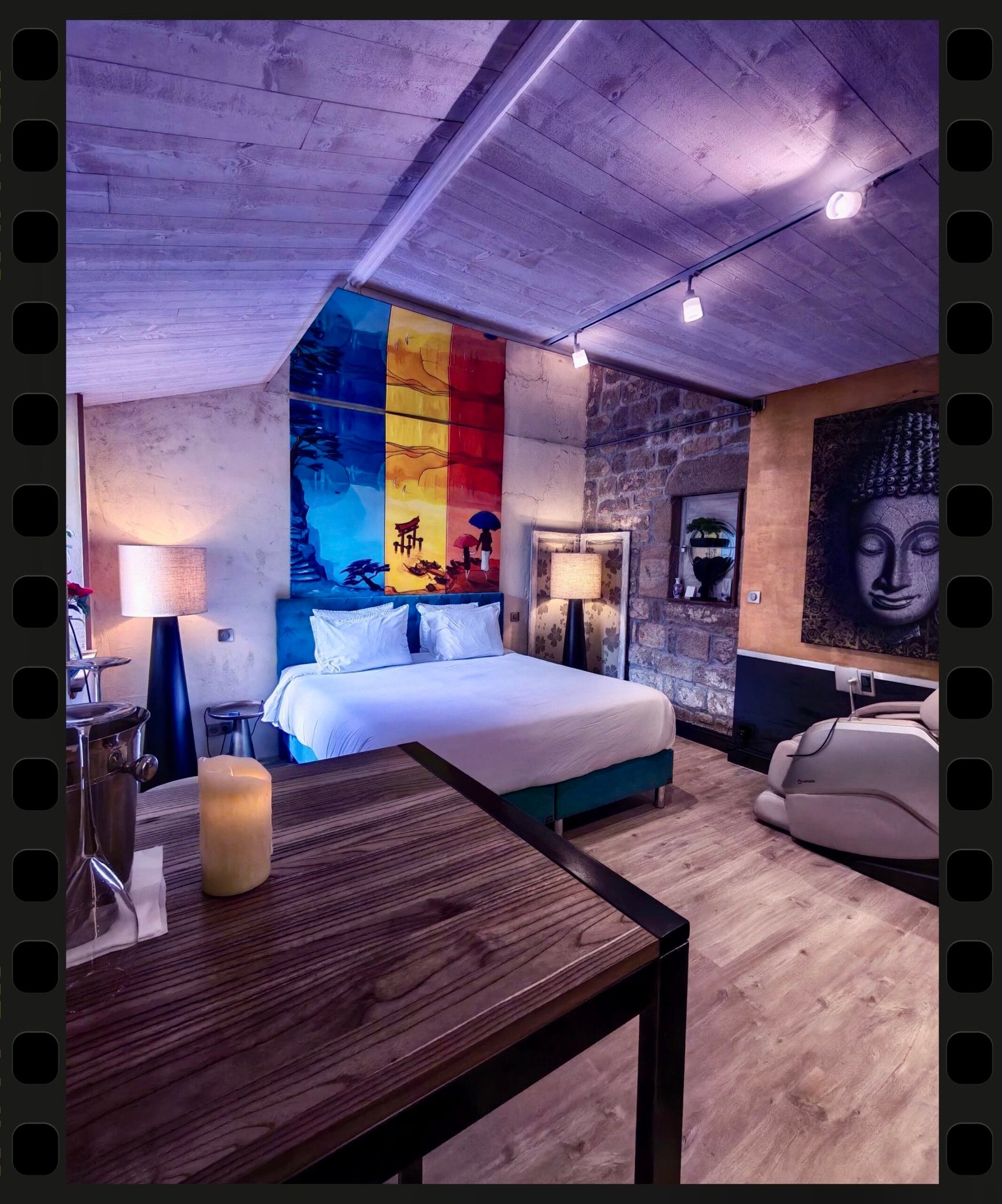 Chambre romantique de la Suite Nirvana avec lit King Size, fauteuil massant et décoration zen aux Suites du Bouddha Bleu à Carnac